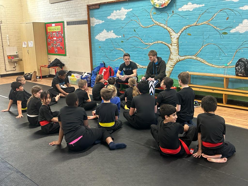 Coaches talking to a class of junior students