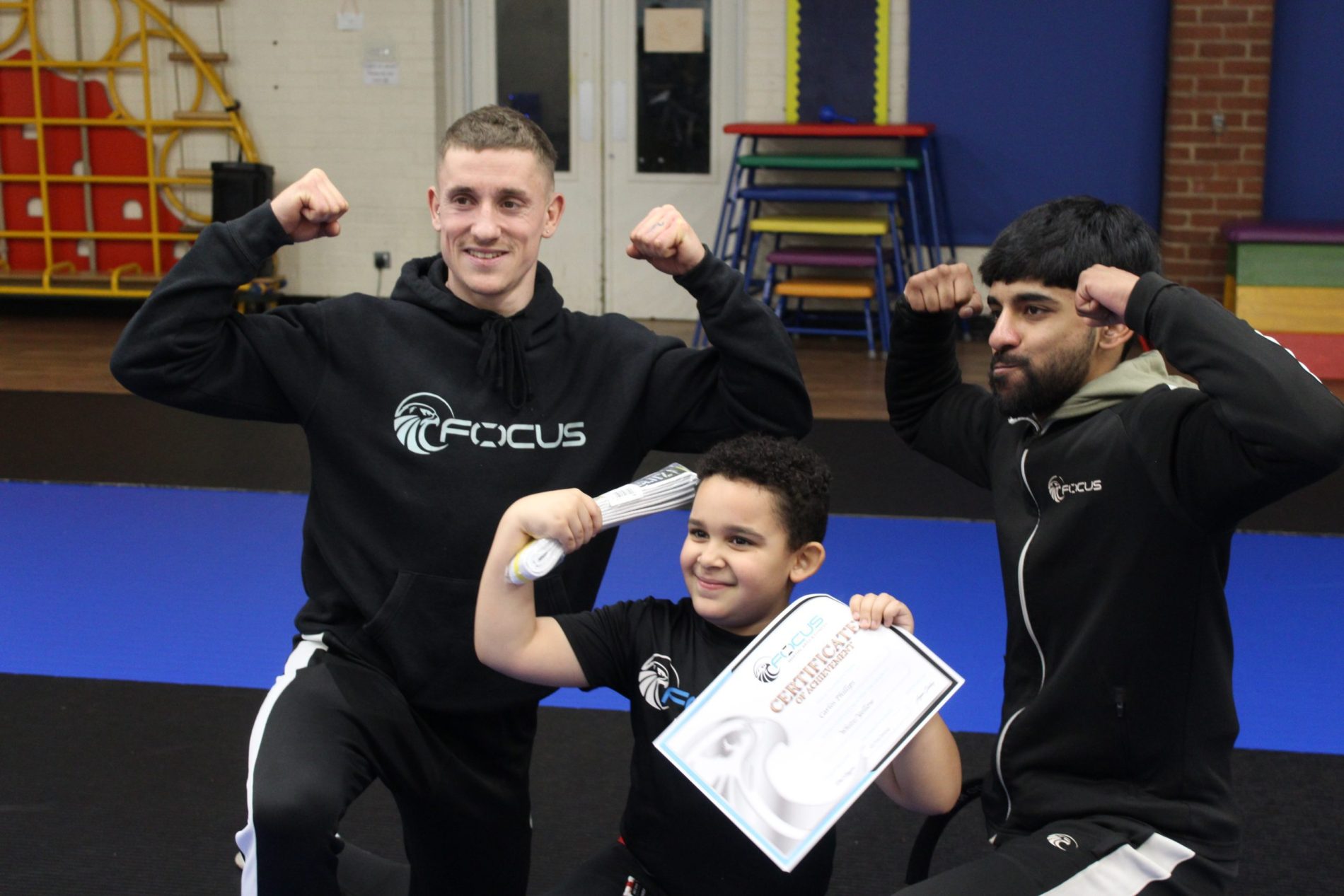 Coaches celebrating a student's grading with his new belt