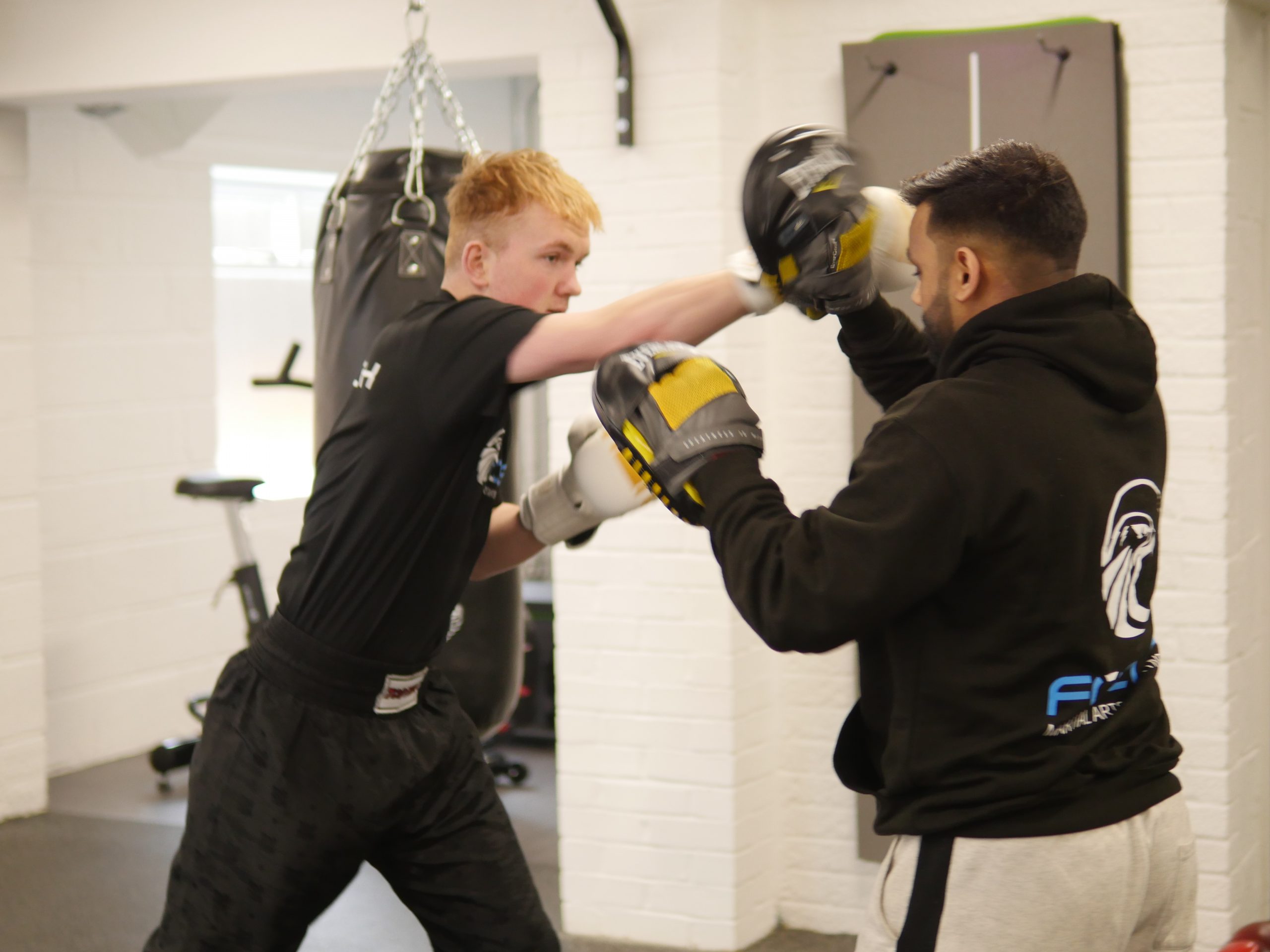 An adult student doing pad work with a Focus Fitness coach