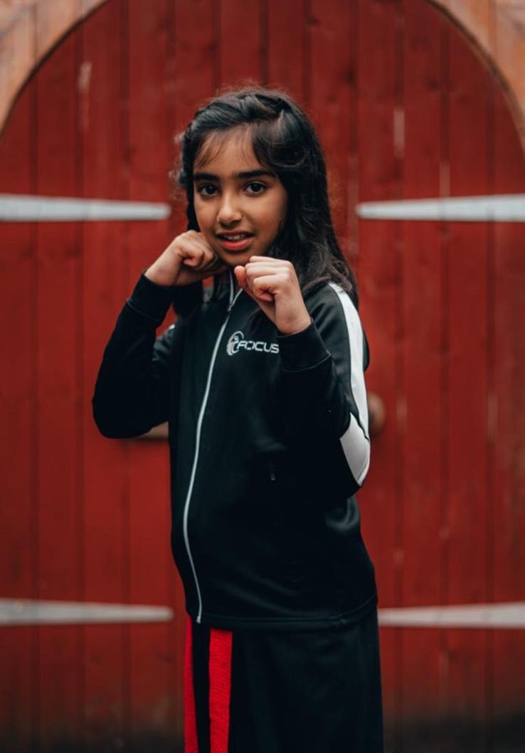 A young student in Focus Fitness tracksuit ready to train