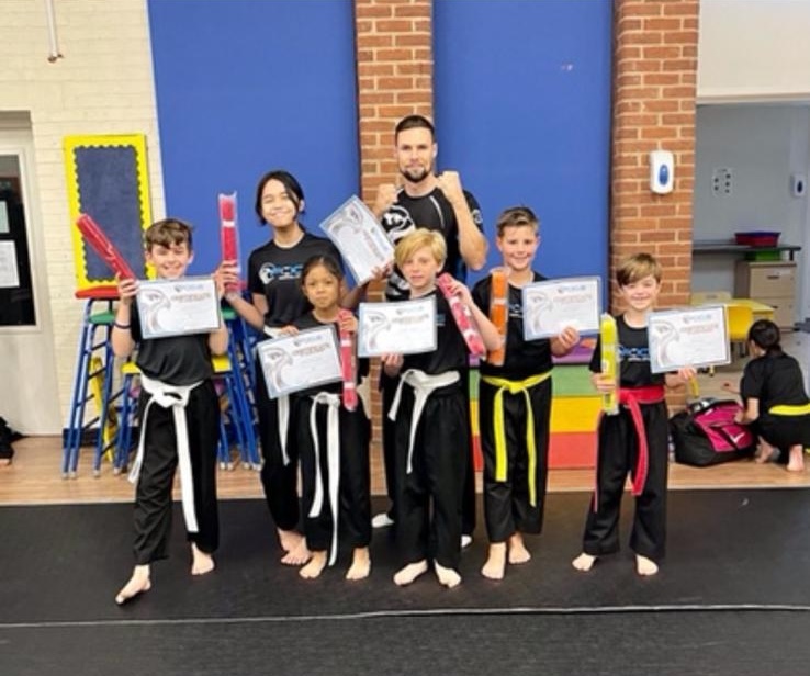 Dragons and Juniors students holding their certificates after a grading